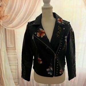 NWOT Faux leather women’s biker jacket with embroidery and metal accents.